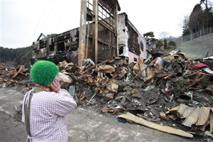 瓦礫となった自宅を見つける被災者