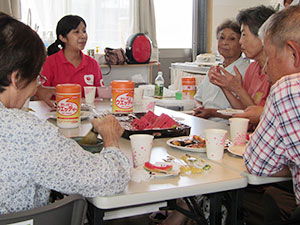 お茶やお菓子を食べながら談笑する参加者の皆さんとAARの田中晴子