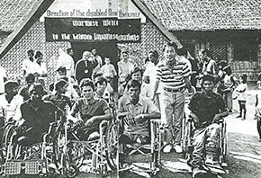 People in wheelchairs gather in front of the building.