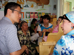 タジキスタンで障害児の親と話す河野氏（左）