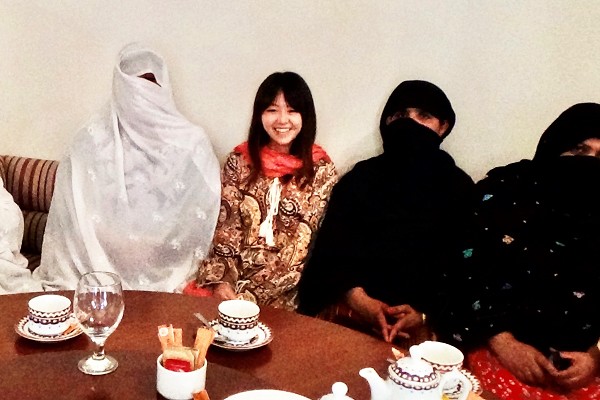 女性たちとともに食卓を囲む藤田。笑顔がはじける。テーブルにはティーカップやグラスが並ぶ
