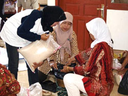 障害者学校の先生たちの協力で米を袋に詰める