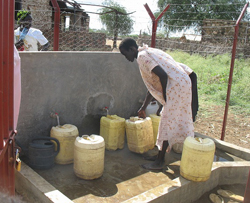 水栓所でポリタンクに水を汲む女性