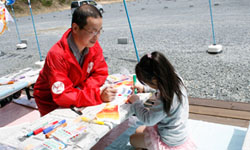 こいのぼりに絵を描く女の子と東京事務局の直江篤志