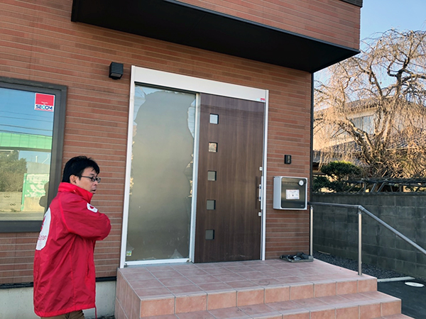 グループホーム笑の玄関前の様子を確認する当会事務局長の堀江良彰
