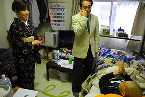 仮設住宅でうぐいすの鳴き真似をする江戸家猫八さんと、民謡歌手の千田けい子さん