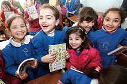 AARの配付した教材を手に取り喜ぶシリア難民の子どもたち