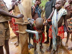 6人ほどの子どもたちがAARが建設した井戸の周りに集まり、水を飲んでいます