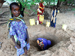 水を汲むための穴の前の子ども