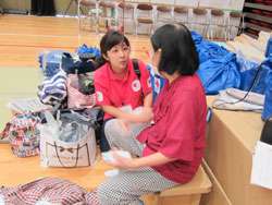 被災者から話を伺うAAR田中晴子（左）