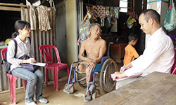 車いすの利用者にインタビューするソパノさんとAARカンボジア事務所の園田知子