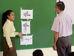 黒板には魚の絵が数枚貼られている　参加者の女性が模擬授業を実施