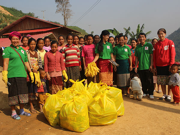 村人が清掃を行い、集めた大きなゴミ袋を前にして並んで撮影