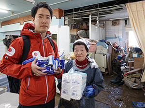 AAR緊急支援チームの生田目が、地域活動支援センターげんきの職員の方へ支援物資を渡している