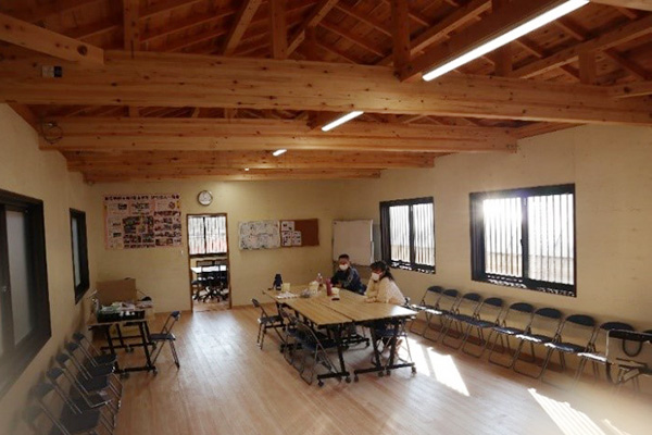 新しい作業所の中は、木の床や天井になり、真ん中にはテーブルがおかれ利用者が座っている。明るい日差しが差し込んでいる
