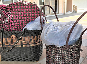 ピンクやオリーブ色をした完成した紙製の買い物袋が並ぶ。編み込んだデコボコが綺麗にデザインとなっている