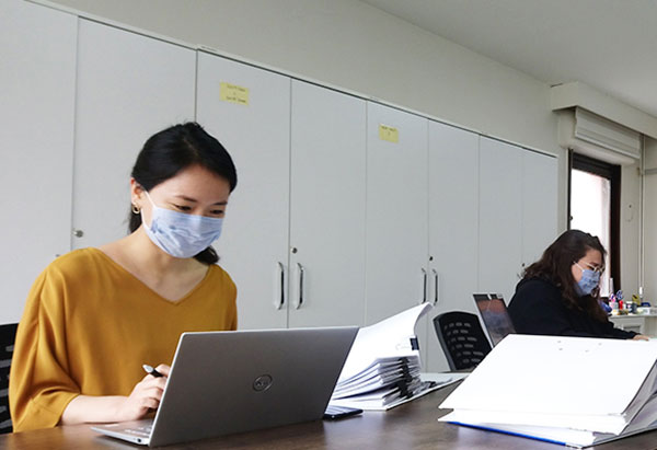 大澤と現地スタッフが事務所内のパソコンで作業をしている