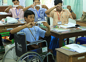 A boy in a wheelchair takes a class.