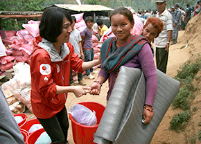 AAR staff delivers daily necessities to a woman affected by the earthquake.