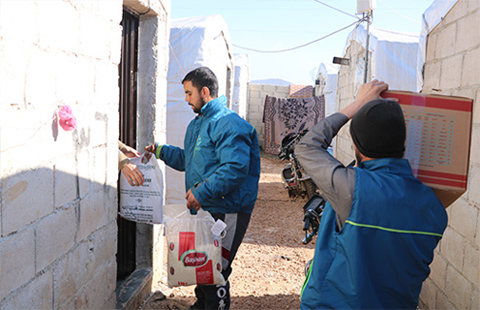 Two staff carrying cardboard boxes