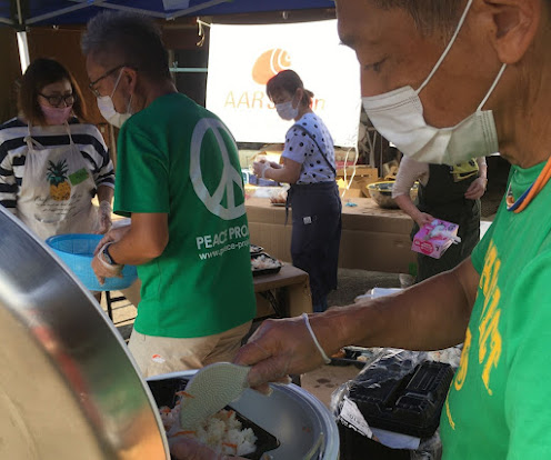 AAR Director Kato (Representative of NPO Peace Project) serving rice cooked in a rice cooker.