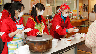 Vice President of AAR Taki Kato (right) serving food in the soup kitchen (2011)