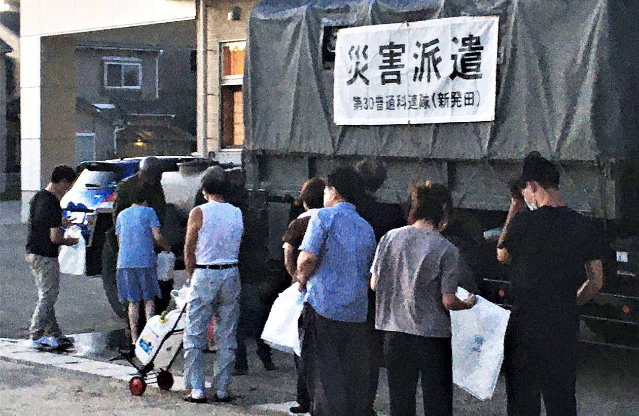 Disaster victims were waiting for water at a shelter set up at the Arakawa Community Center in Murakami City on August 5.