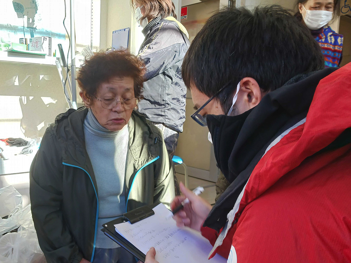 AAR staff interviewing an elderly woman at an evacuation center