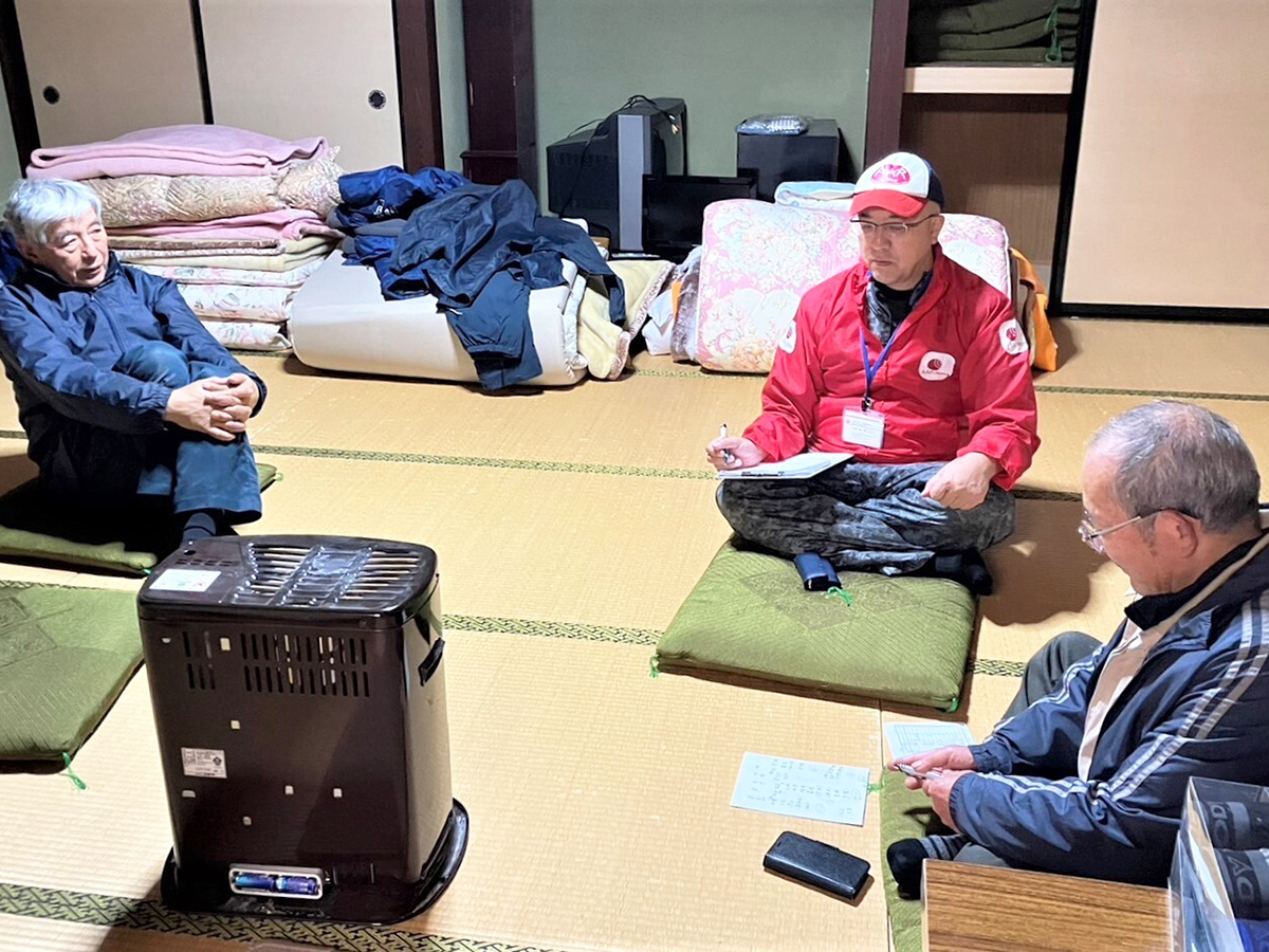 Three men are sitting and talking in a tatami room.