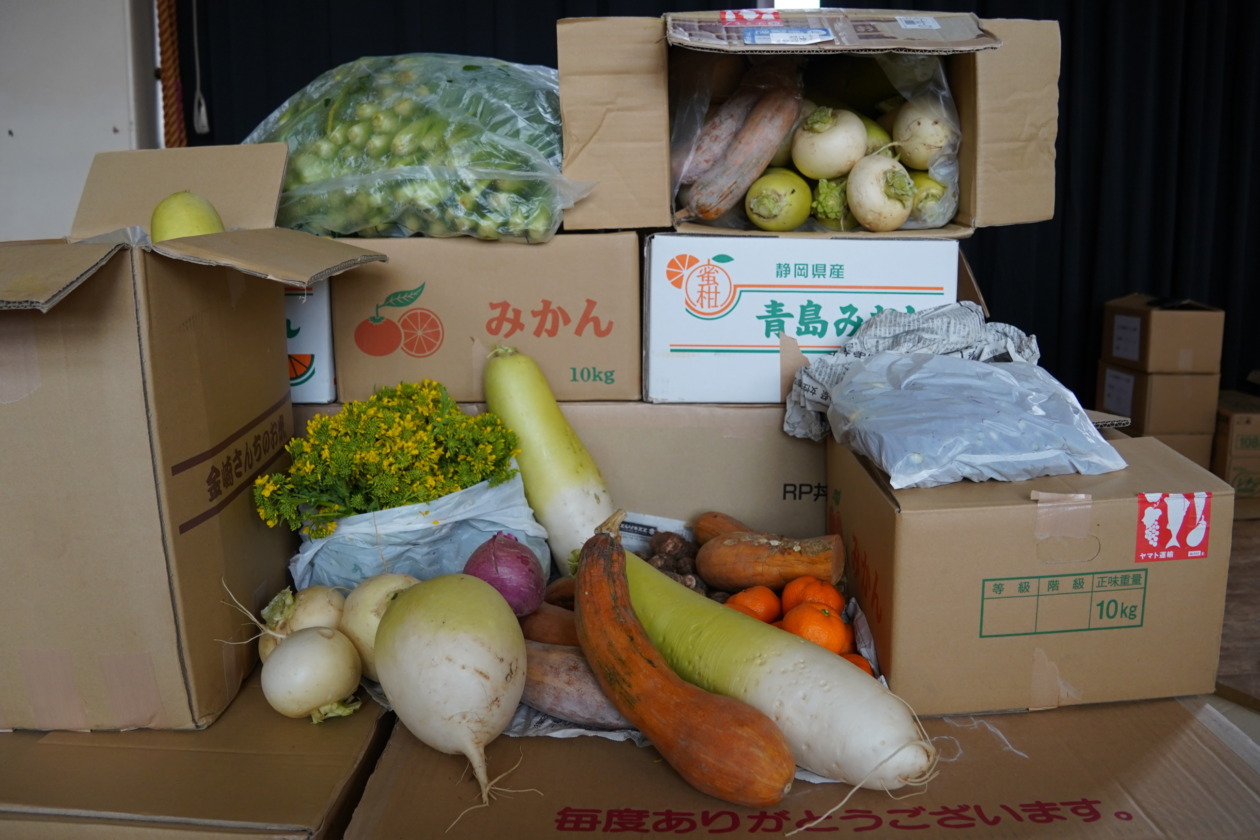 Eight cardboard boxes of Japanese radishes, turnips, pumpkins, rape blossoms, and many other fresh vegetables are piled up
