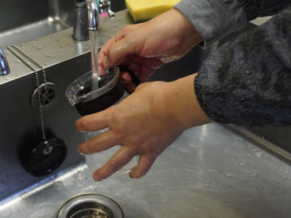 Photo of a woman washing dishes in the sink