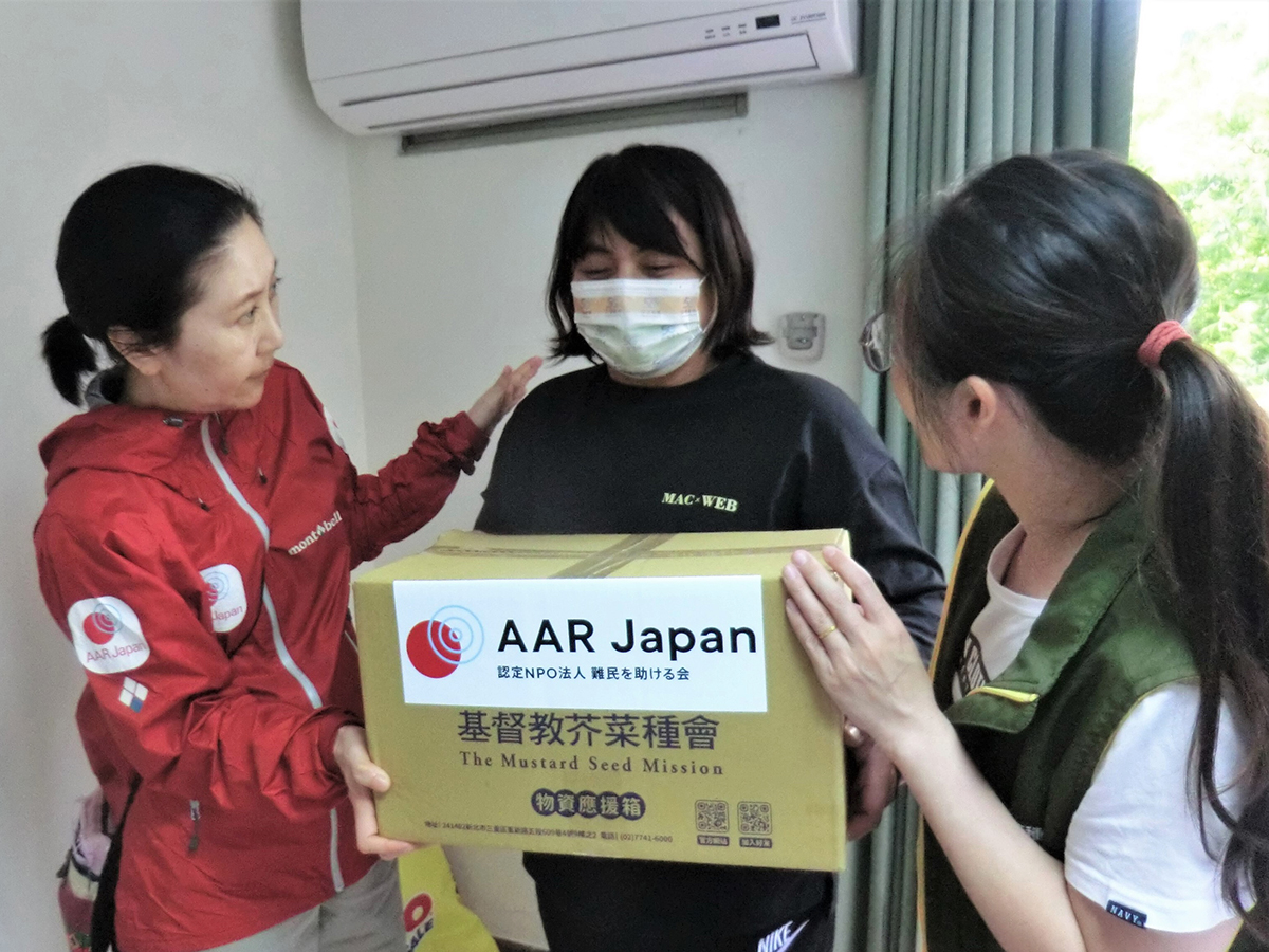 AAR staff with a woman who received a cardboard box
