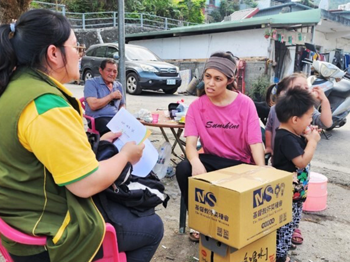 A staff member talks with a woman who received supplies