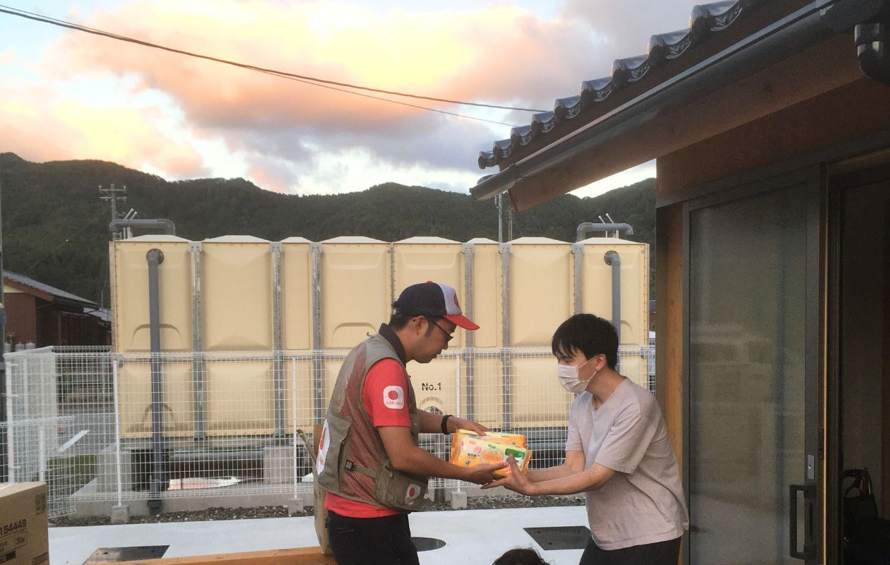 a man is handing out relief supplies to the other man