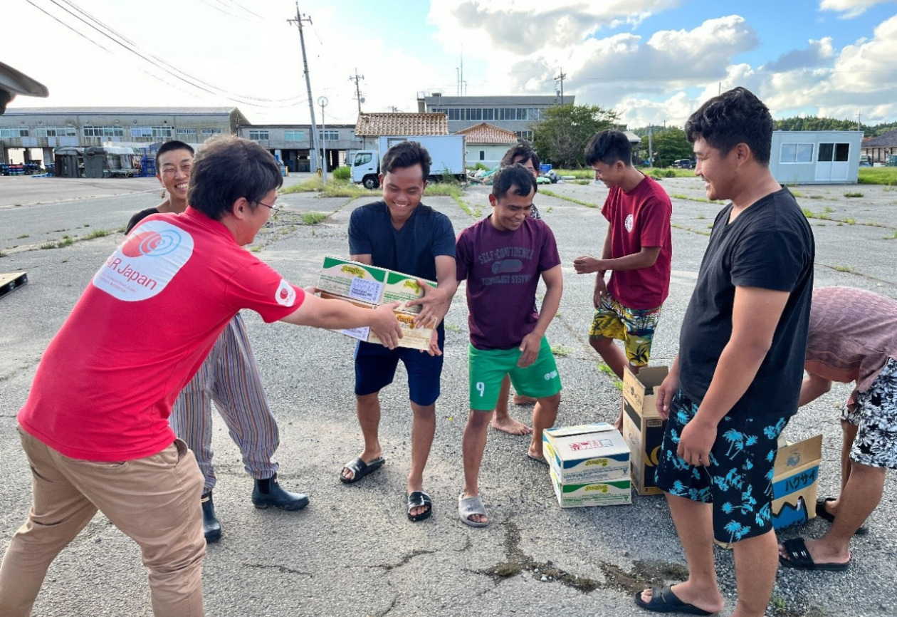 A man is handing supplies to trainees