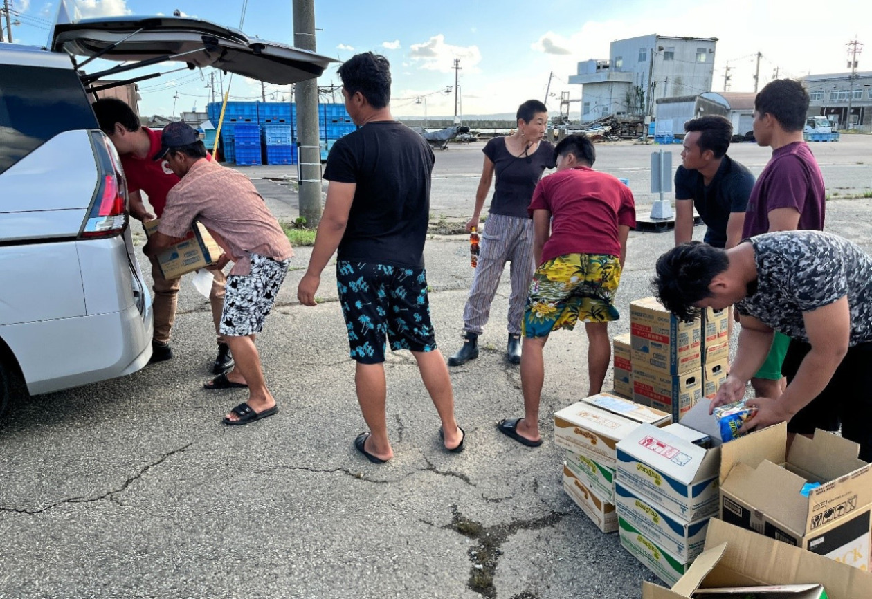 trainees are helping a man taking supplies of from a car