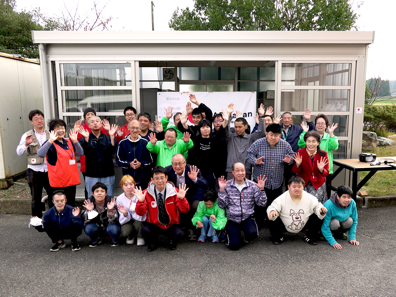 In front of the one-story shiitake mushroom drying huts, about 20 people, young and old, men and women, turned toward us and took a commemorative photo with smiles on their faces