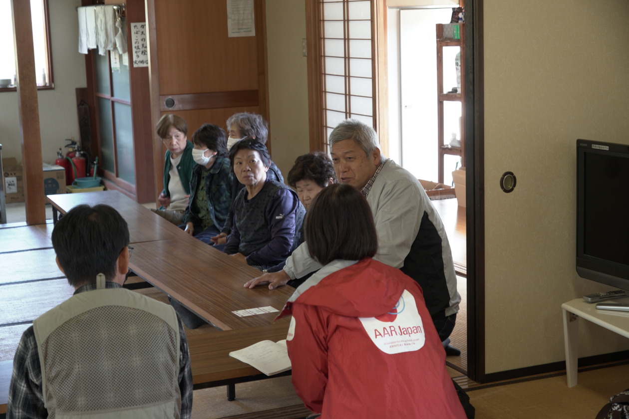 Residents and AAR staff sit and talk in a tatami room at a meeting place