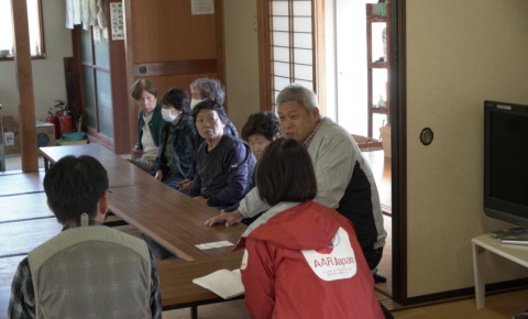 Residents and AAR staff sit and talk in a tatami room at a meeting place