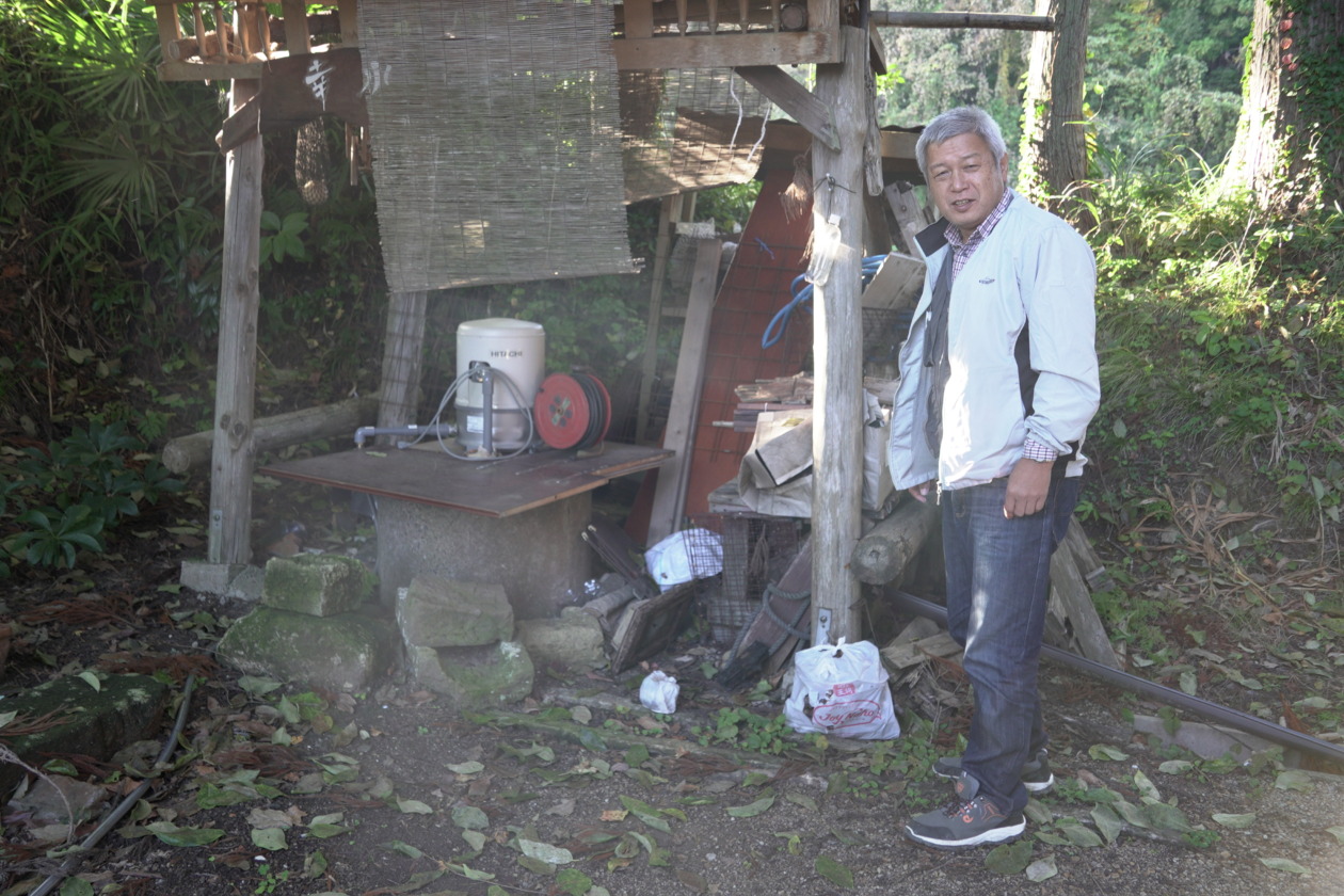 A man stands next to a well