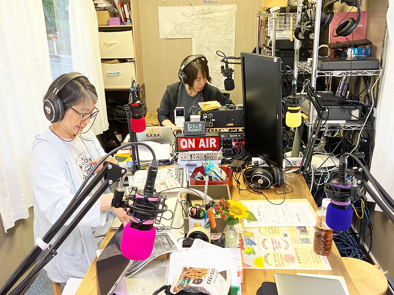 Two people work inside a container lined with equipment