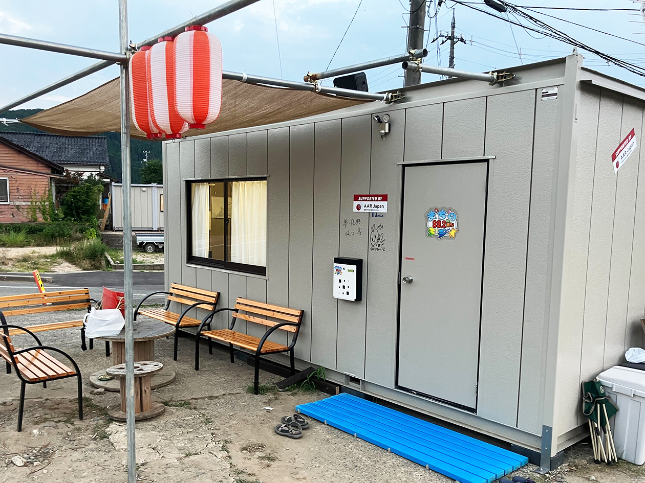 Exterior of the container. Desks and chairs are lined up outside