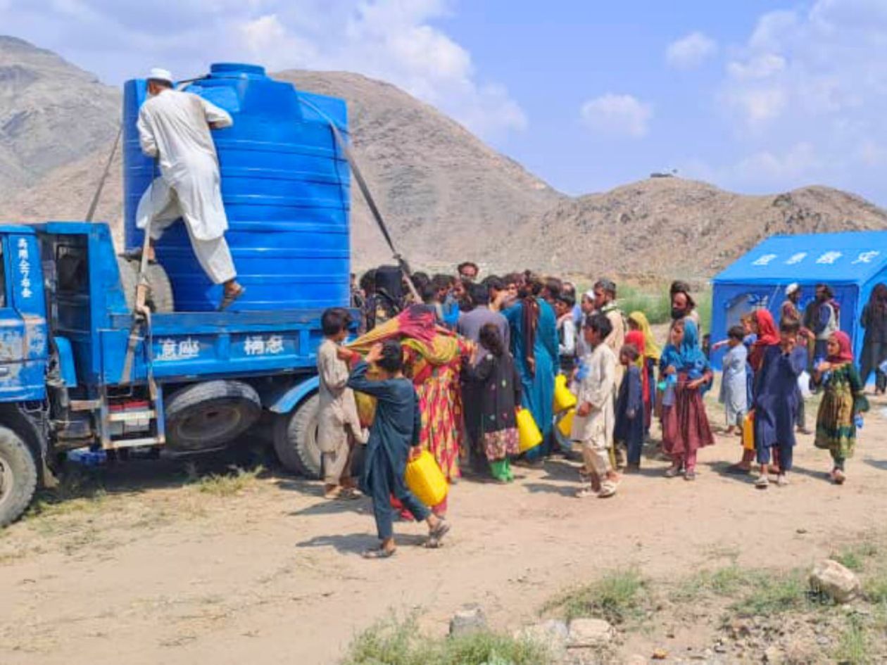 Large crowds are gathering around a water truck