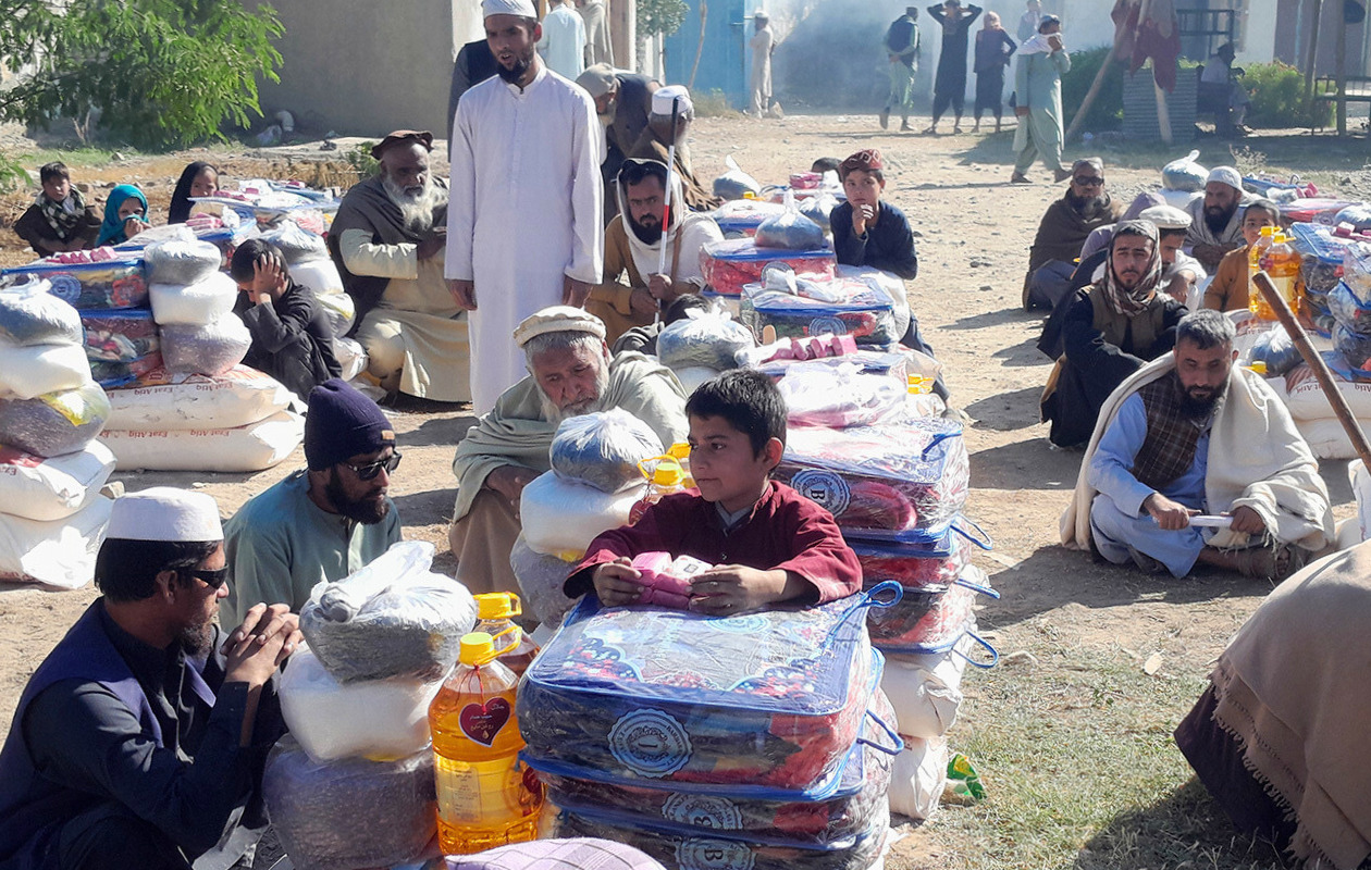 People are sitting next to the relief supplies they received