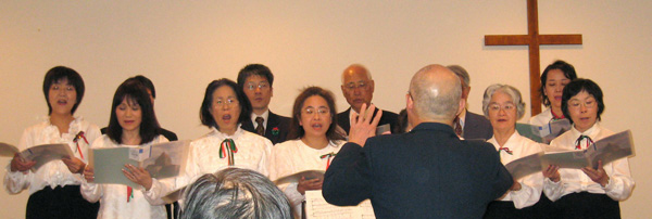 生駒様の指揮のもと歌う約10名の合唱団