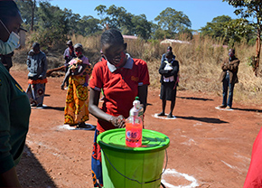 アフリカで水タンクから水を出し手を洗う男性
