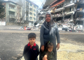 被災した親子。後には倒壊した建物がある