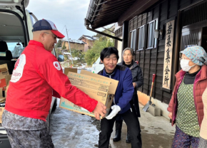 支援物資が入った段ボールを手渡すAARスタッフ