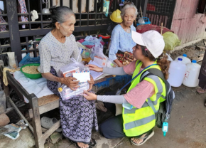 被災した高齢の女性に支援物資を届けるAAR現地スタッフ