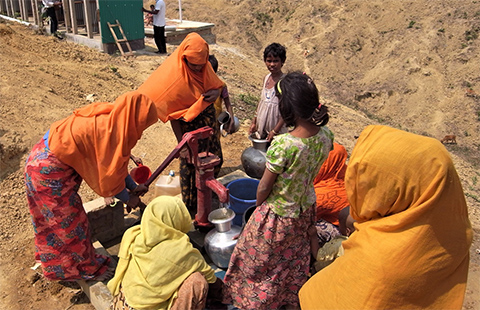 外にある井戸で水を汲んでいる女性たちの様子